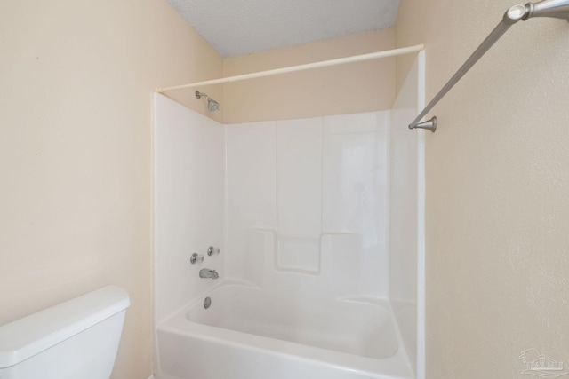 full bathroom with a textured ceiling, washtub / shower combination, and toilet