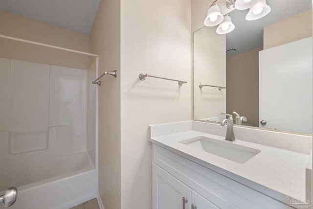 full bathroom with vanity, washtub / shower combination, and a textured ceiling