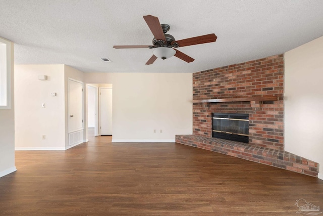 unfurnished living room with a ceiling fan, baseboards, wood finished floors, visible vents, and a textured ceiling