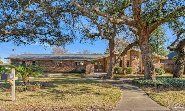 mid-century home featuring a front lawn and brick siding