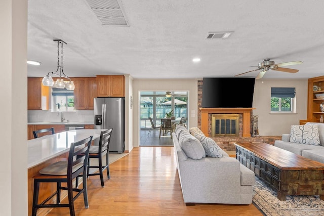 living room featuring light wood-style floors, a wealth of natural light, and visible vents