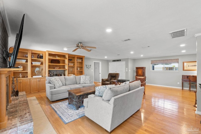 living room featuring light wood-type flooring, visible vents, and recessed lighting