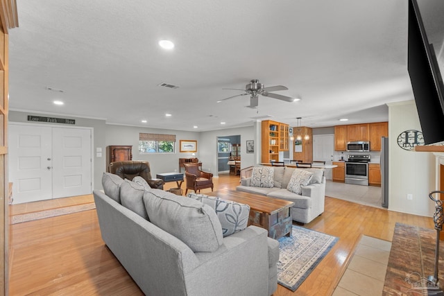 living area featuring recessed lighting, visible vents, light wood-style flooring, and ceiling fan with notable chandelier