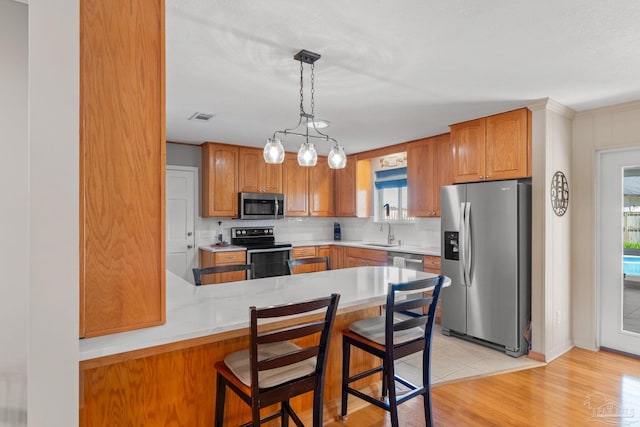 kitchen featuring stainless steel appliances, tasteful backsplash, a sink, and a healthy amount of sunlight