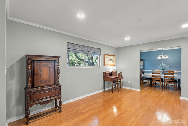 interior space with light wood-style flooring, baseboards, a notable chandelier, and ornamental molding