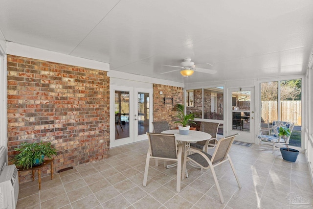 sunroom featuring a ceiling fan and french doors