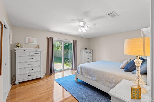 bedroom with access to exterior, visible vents, light wood-style flooring, and a ceiling fan