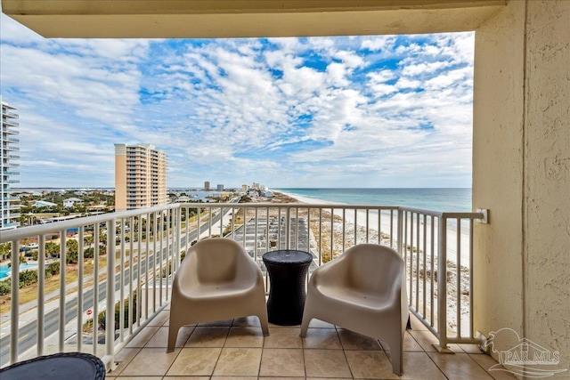 balcony featuring a view of the beach and a water view