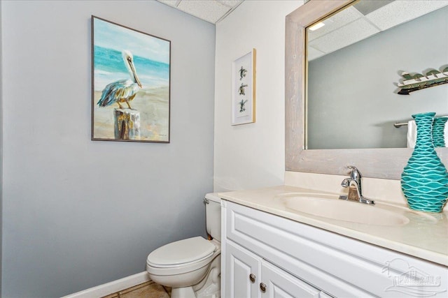 bathroom with toilet, vanity, and tile patterned flooring