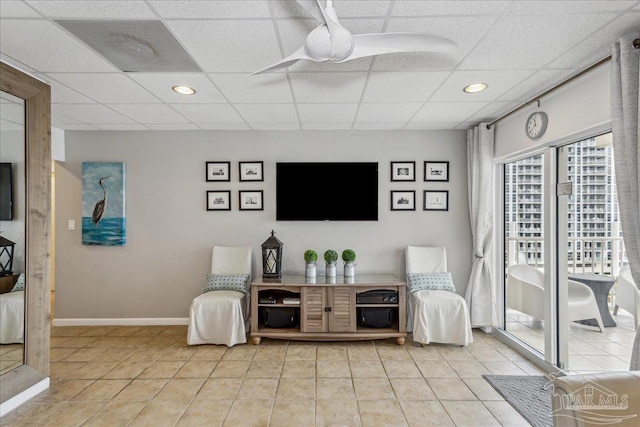 living area featuring light tile patterned floors and a paneled ceiling