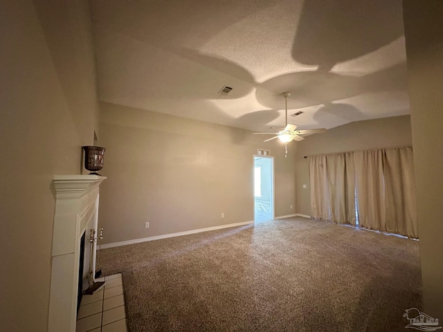 unfurnished living room with ceiling fan, lofted ceiling, carpet flooring, and a fireplace