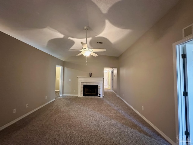 unfurnished living room featuring vaulted ceiling, a tile fireplace, ceiling fan, and carpet flooring