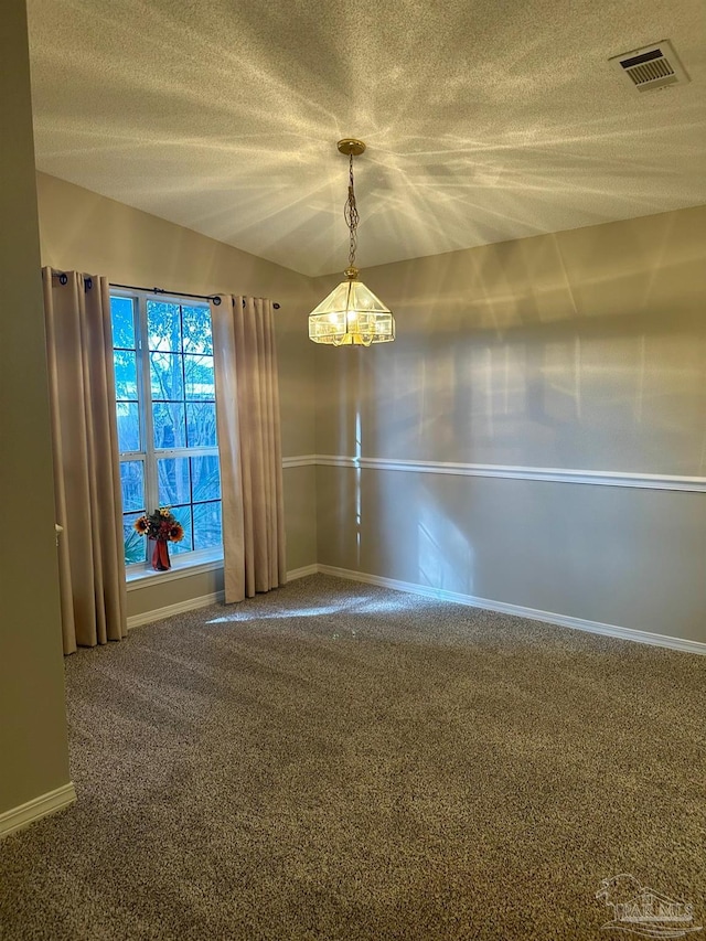 carpeted empty room featuring a textured ceiling