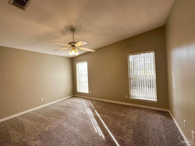 carpeted empty room featuring ceiling fan, lofted ceiling, and a textured ceiling