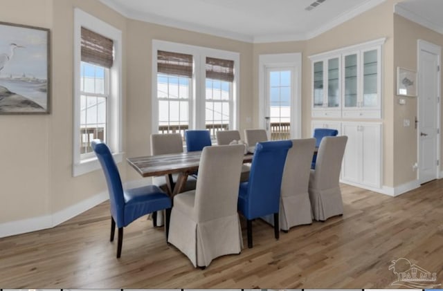 dining area featuring plenty of natural light, light hardwood / wood-style floors, and ornamental molding