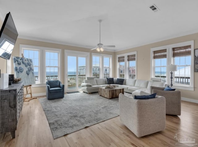 living room with light hardwood / wood-style floors, ceiling fan, and ornamental molding