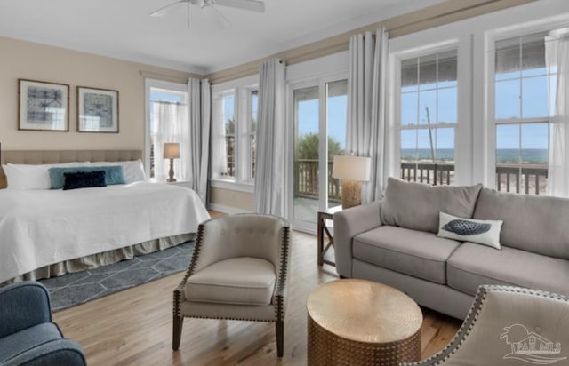 bedroom featuring ceiling fan, light hardwood / wood-style flooring, access to outside, and multiple windows