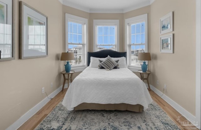 bedroom with light wood-type flooring and ornamental molding