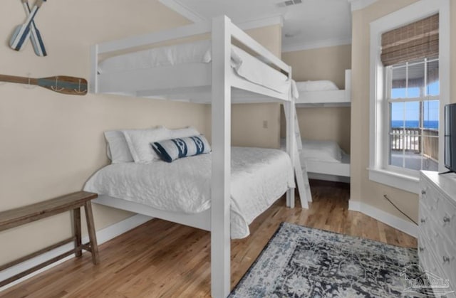 bedroom with crown molding and light wood-type flooring