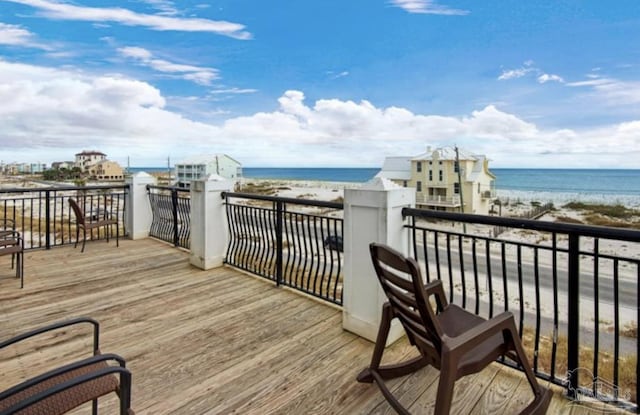 wooden deck featuring a water view and a view of the beach