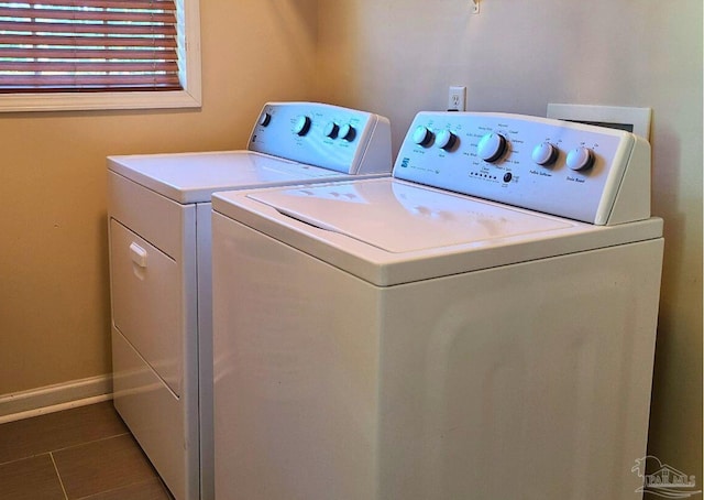 laundry area featuring dark tile patterned flooring and washing machine and clothes dryer