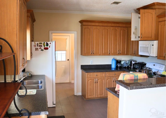 kitchen with kitchen peninsula, a textured ceiling, white appliances, crown molding, and sink