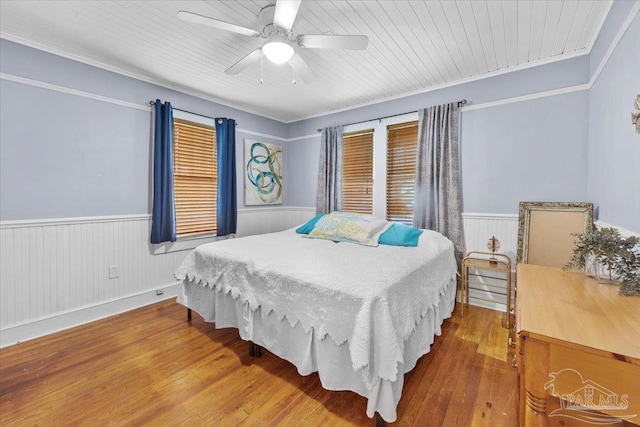 bedroom featuring ornamental molding, wood ceiling, wood-type flooring, and ceiling fan