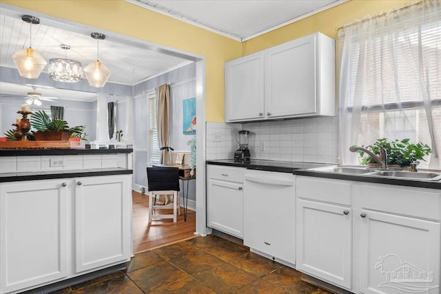 kitchen with white dishwasher, pendant lighting, crown molding, sink, and white cabinets