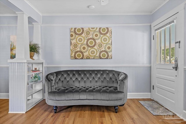 sitting room featuring hardwood / wood-style floors, wooden walls, and crown molding