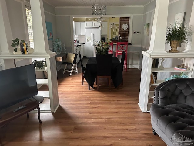 dining area with ornamental molding, wood-type flooring, and decorative columns