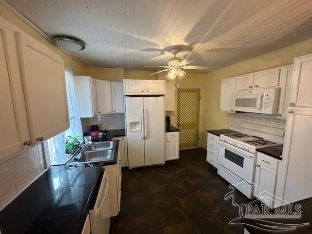 kitchen with white appliances, sink, decorative backsplash, white cabinetry, and ceiling fan