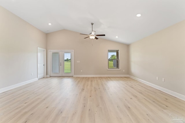 unfurnished room with vaulted ceiling, a healthy amount of sunlight, light hardwood / wood-style floors, and french doors