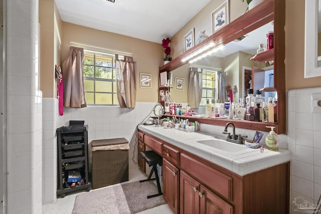 bathroom with tile patterned flooring, vanity, and tile walls