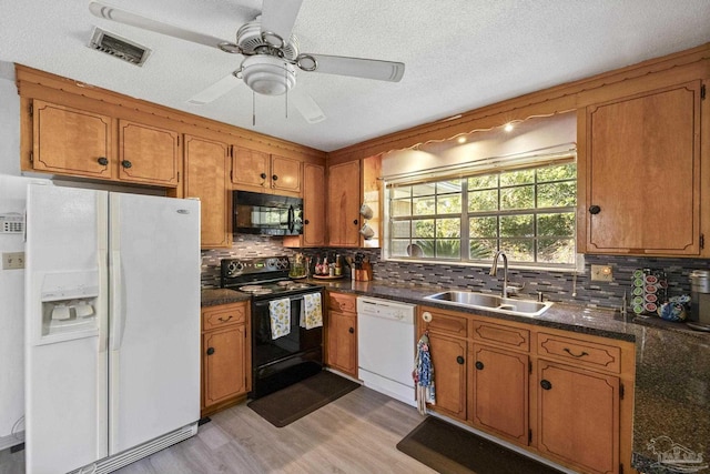 kitchen featuring decorative backsplash, sink, black appliances, and light hardwood / wood-style flooring