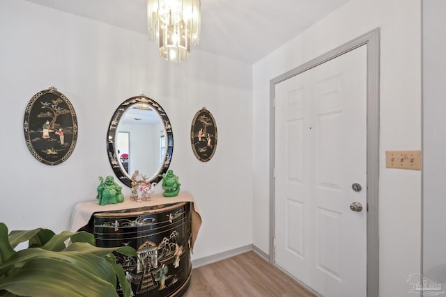 entryway with light wood-type flooring and a chandelier