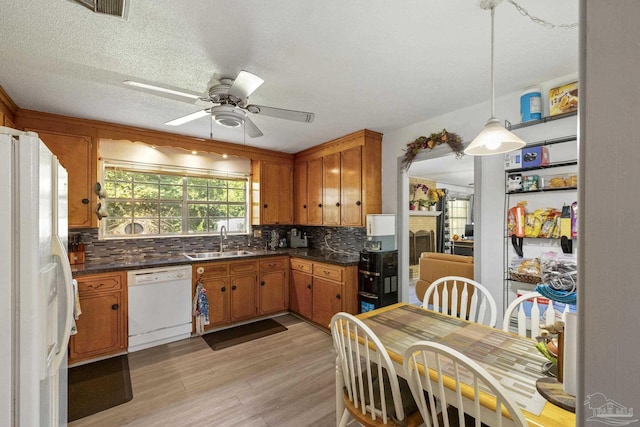 kitchen featuring backsplash, white appliances, ceiling fan, sink, and light hardwood / wood-style floors