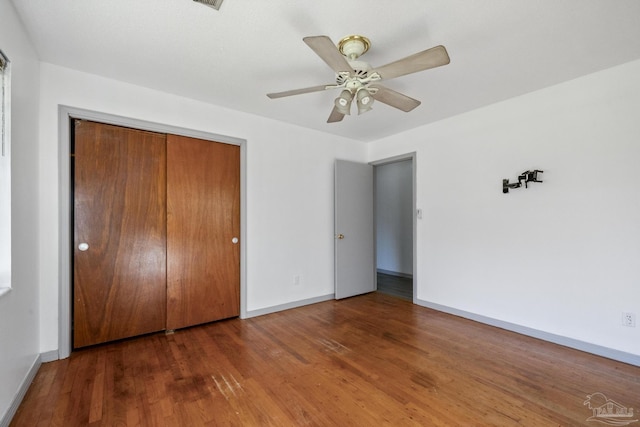 unfurnished bedroom with ceiling fan, a closet, and dark hardwood / wood-style floors