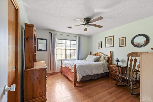 bedroom featuring ceiling fan, a textured ceiling, and light hardwood / wood-style flooring