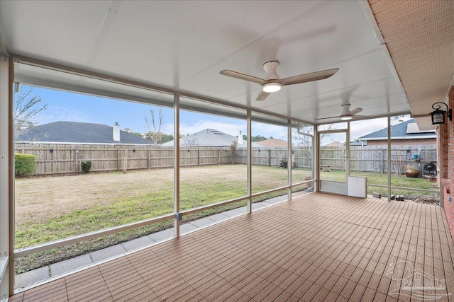 unfurnished sunroom with ceiling fan