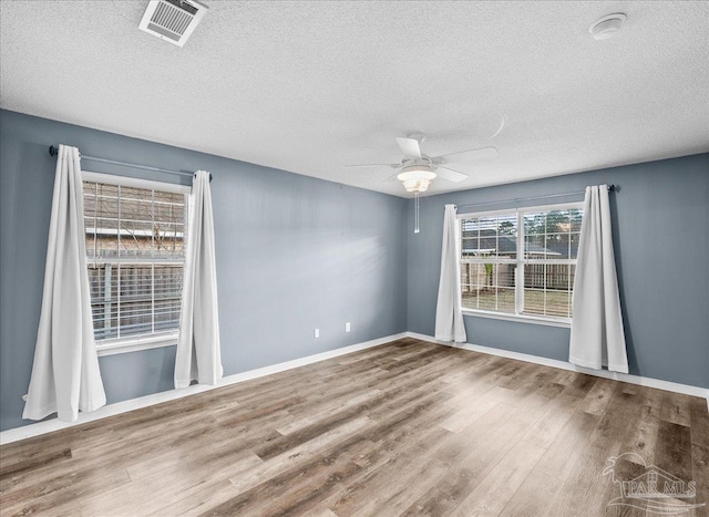 spare room featuring hardwood / wood-style floors, a textured ceiling, and ceiling fan