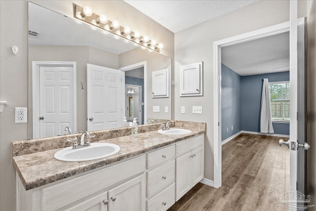 bathroom with vanity, hardwood / wood-style floors, and a textured ceiling