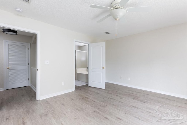 unfurnished bedroom with ceiling fan, light hardwood / wood-style flooring, a textured ceiling, and ensuite bathroom