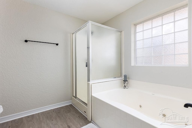 bathroom featuring plus walk in shower and hardwood / wood-style floors