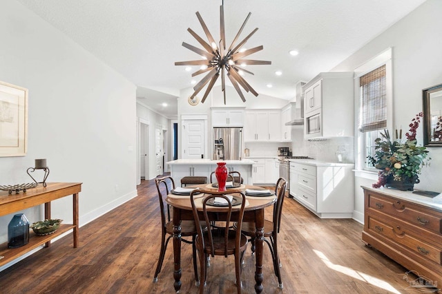 dining area featuring an inviting chandelier, baseboards, lofted ceiling, and wood finished floors