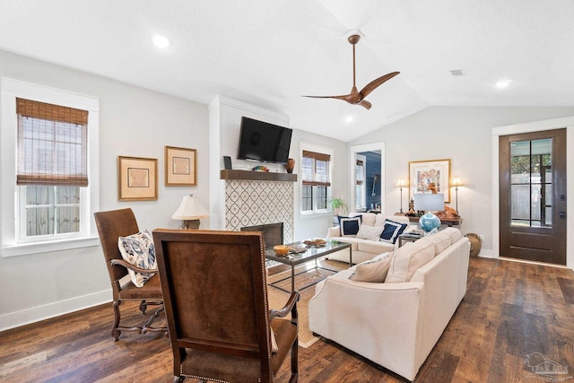 living area with lofted ceiling, plenty of natural light, a fireplace, and dark wood-type flooring