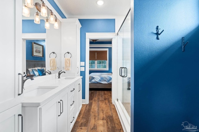 full bath featuring a sink, wood finished floors, ensuite bath, and a shower stall