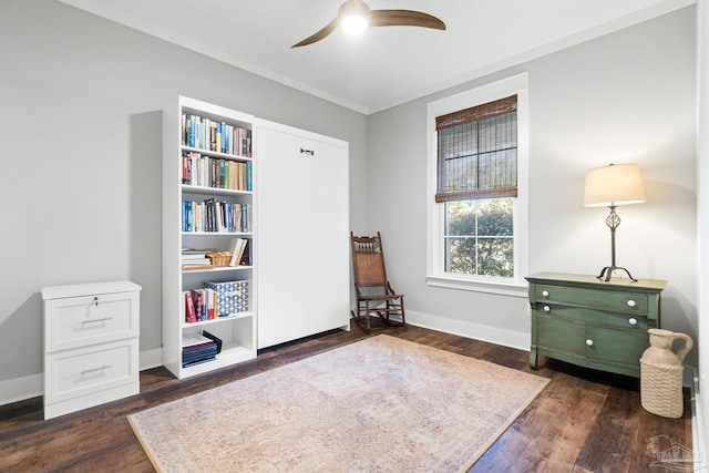 living area featuring baseboards, ceiling fan, and dark wood-style flooring