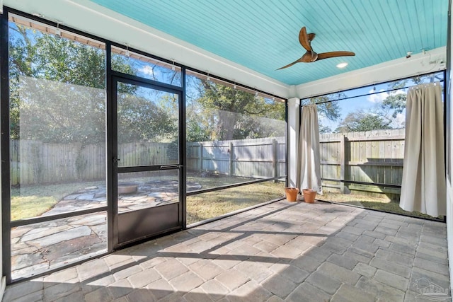 unfurnished sunroom with wood ceiling and ceiling fan