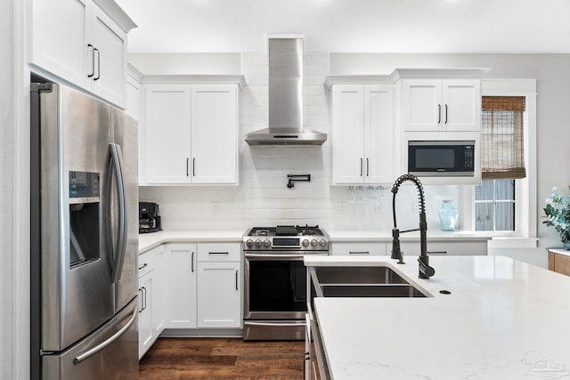 kitchen with stainless steel appliances, tasteful backsplash, dark wood-style floors, and wall chimney exhaust hood