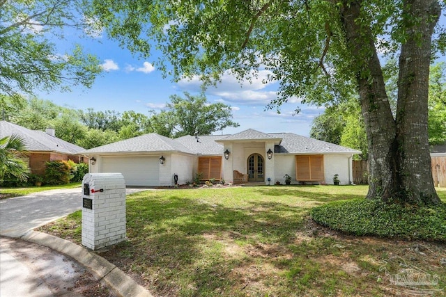 ranch-style home with driveway, french doors, an attached garage, fence, and a front yard